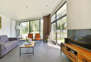 Woonkamer van Lodge Grand Modern met Finse sauna bij Holiday Park De Lochemse Berg, Nederland, licht en modern.