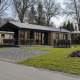 Moderne Lodge im Holiday Park De Lochemse Berg in den Niederlanden, mit Terrasse und Gartenmöbeln.