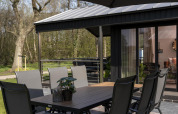 Outdoor dining table and chairs on a terrace at Terrace Lodge, Holiday Park De Lochemse Berg, Netherlands.