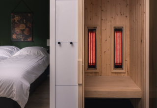 Dormitorio moderno y sauna privada con paneles infrarrojos en Kubus Lodge, Holiday Park De Lochemse Berg, Países Bajos.