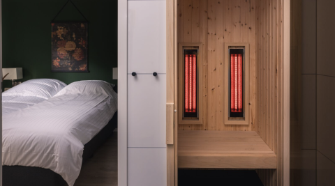 Dormitorio moderno y sauna privada con paneles infrarrojos en Kubus Lodge, Holiday Park De Lochemse Berg, Países Bajos.