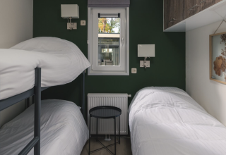Kleine slaapkamer met stapelbed en eenpersoonsbed in Kubus Lodge + sauna, Holiday Park De Lochemse Berg, Nederland.