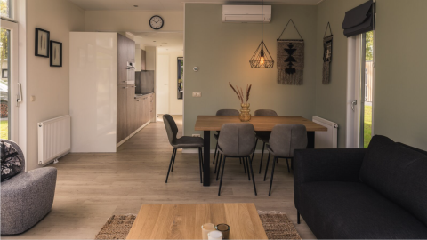 Moderne woon- en eetruimte in Kubus Lodge met gezellige inrichting bij Holiday Park De Lochemse Berg, Nederland.
