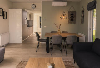 Moderne woon- en eetruimte in Kubus Lodge met gezellige inrichting bij Holiday Park De Lochemse Berg, Nederland.