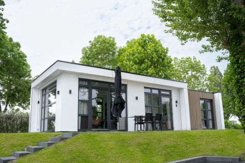 Moderne lodge Villa Maritiem bij MarinaPark Bad Nederrijn in Nederland, met grote ramen en terras.