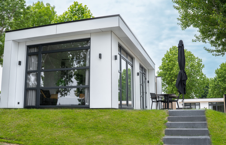 Moderna cabaña Villa Maritiem en MarinaPark Bad Nederrijn, Países Bajos, con ventanales y terraza exterior.