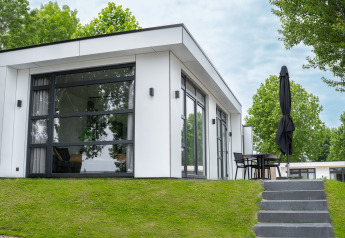 Moderne Villa Maritiem-lodge ved MarinaPark Bad Nederrijn i Holland med store vinduer og terrasse.