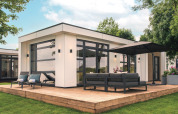 Moderne lodge Villa Maritiem aan MarinaPark Bad Nederrijn met houten terras, zitset en grote parasol.