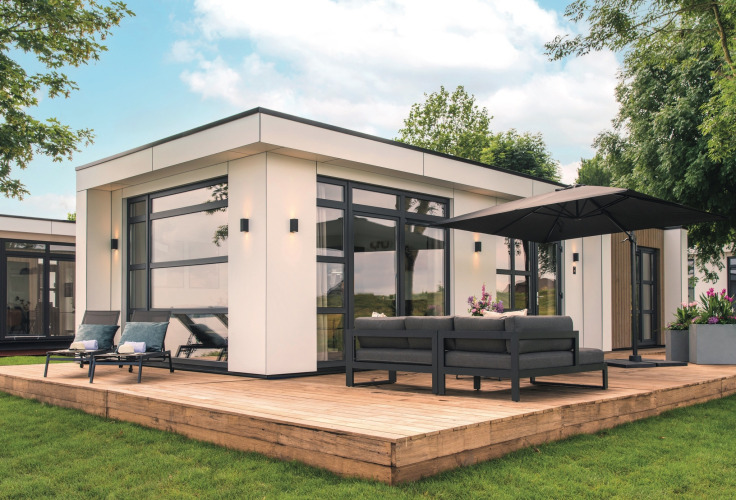 Lodge moderno Villa Maritiem en MarinaPark Bad Nederrijn con terraza de madera, sofás y sombrilla grande.