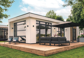 Moderne lodge Villa Maritiem ved MarinaPark Bad Nederrijn med træterrasse, loungemøbler og parasol.