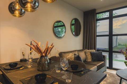 Elegante sala y comedor en Villa Maritiem, MarinaPark Bad Nederrijn, con grandes ventanales y decoración moderna.