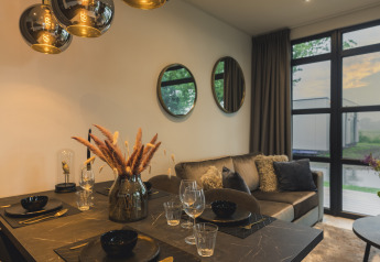 Moderne woon- en eetruimte in Villa Maritiem, MarinaPark Bad Nederrijn, elegant ingericht met grote vensters.