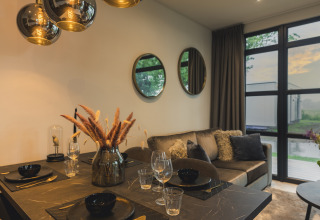 Elegante sala y comedor en Villa Maritiem, MarinaPark Bad Nederrijn, con grandes ventanales y decoración moderna.