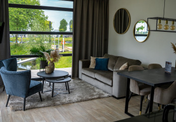 Modern lodge living room at Villa Maritiem, MarinaPark Bad Nederrijn, Netherlands, with waterfront view.