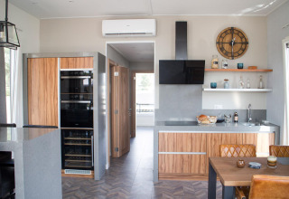 Moderne Küche in der Waterlodge 4 am Zuiderzee, Niederlande, mit Holzmöbeln, Esstisch und offenem Regal.