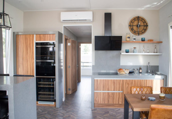 Moderne Küche in der Waterlodge 4 am Zuiderzee, Niederlande, mit Holzmöbeln, Esstisch und offenem Regal.