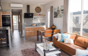 Modern living and kitchen area at Waterlodge 4 in Zuiderzee, Netherlands, featuring large windows and cozy décor.