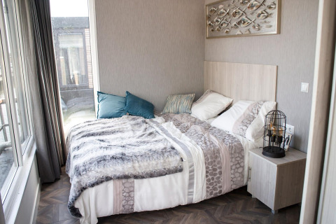 Modernes Schlafzimmer in der Waterlodge 4 am Zuiderzee in den Niederlanden mit Doppelbett und Nachttisch.