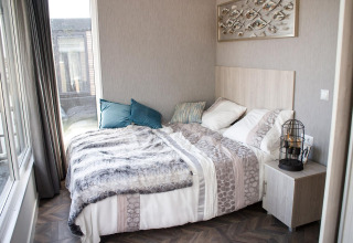 Modernes Schlafzimmer in der Waterlodge 4 am Zuiderzee in den Niederlanden mit Doppelbett und Nachttisch.