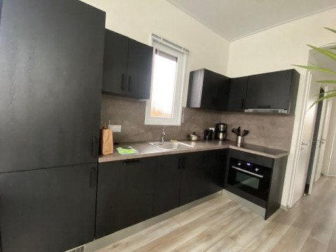 Moderne schwarze Küche in Waterlodge 6, Zuiderzee, Niederlande, mit Fenster, Ofen und Kaffeemaschine.