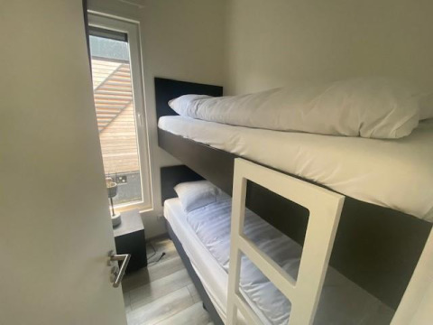 Schmales Zimmer mit Etagenbett und großem Fenster in der Waterlodge 6 am Zuiderzee, Niederlande.