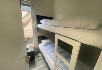 Schmales Zimmer mit Etagenbett und großem Fenster in der Waterlodge 6 am Zuiderzee, Niederlande.