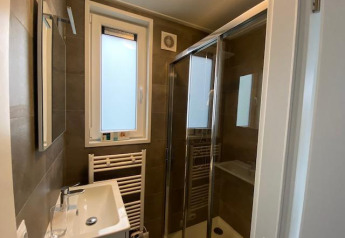 Moderne badkamer met douche, spiegel, wastafel en raam in Waterlodge 6 te Zuiderzee, Nederland.