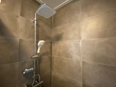 Moderne Dusche mit großen Fliesen im Badezimmer der Waterlodge 6 in Zuiderzee, Niederlande.