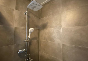 Moderne douche met wandtegels in Waterlodge 6, Zuiderzee, Nederland, met beide douchekoppen zichtbaar.