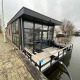 Lodge flottant moderne à Zuiderzee aux Pays-Bas, avec terrasse et larges baies vitrées sur l'eau.