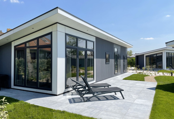 Moderna Premium Lodge al Kompas Camping - Westende in Belgio, con terrazza soleggiata e lettini.