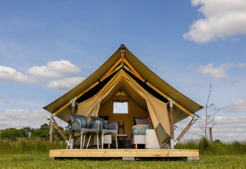 Tente safari au CharmeCamping De Regge-Vallei aux Pays-Bas avec mobilier confortable et vue sur la nature.