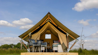Tenda safari al CharmeCamping De Regge-Vallei nei Paesi Bassi, arredata con stile e vista sulla natura.