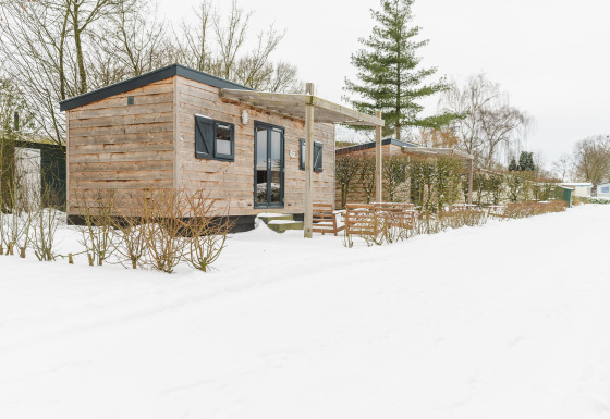 Petite maison en bois au Holiday Park Mölke aux Pays-Bas, entourée de neige et de paysage hivernal.