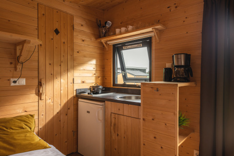 Pequeña cocina acogedora en una tiny house de Holiday Park Mölke en Países Bajos, con paredes de madera.