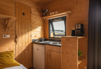 Kompakte Küchenzeile mit Holzverkleidung im Tiny House im Holiday Park Mölke in den Niederlanden.