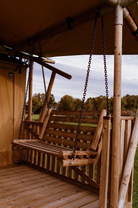 Balançoire en bois suspendue sur la terrasse d'une tente safari Groupaccommodation 'de Blokhut', Eigen Wijze, Pays-Bas.