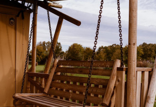 Wooden porch swing at a safari tent named Groupaccommodation 'de Blokhut', Holiday park Eigen Wijze, Netherlands.