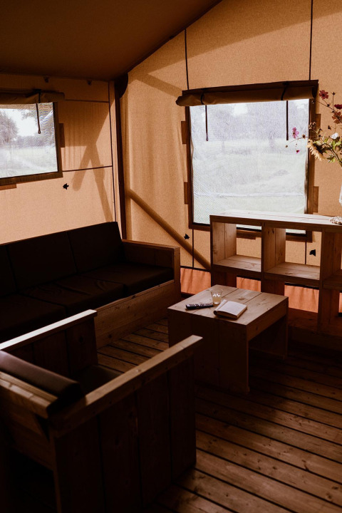 Safari telt interiør i Groupaccommodation 'de Blokhut' ved Holiday park Eigen Wijze, Holland, med træmøbler.