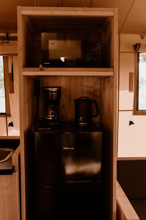 Keukenhoek in safaritent Groupaccommodatie 'de Blokhut' met magnetron, koffiezetapparaat en koelkast.
