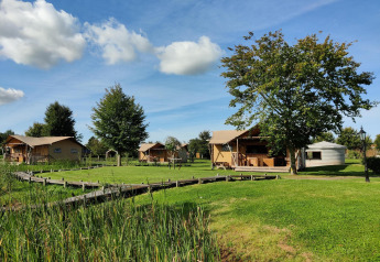 Safari-Zelte und Grünflächen bei Groupaccommodation 'de Blokhut' im Holiday park Eigen Wijze, Niederlande.