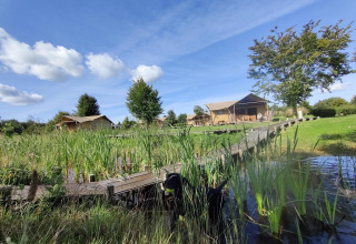 Tienda safari Groupaccommodation 'de Blokhut' en Holiday park Eigen Wijze, Países Bajos, junto a un lago.