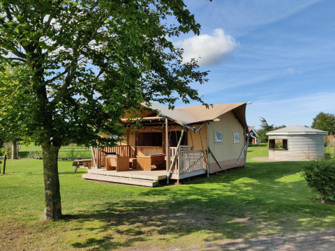 Tienda safari Groupaccommodation 'de Blokhut' en Holiday park Eigen Wijze en los Países Bajos, rodeada de verde.