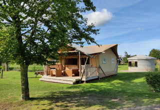 Tienda safari Groupaccommodation 'de Blokhut' en Holiday park Eigen Wijze en los Países Bajos, rodeada de verde.