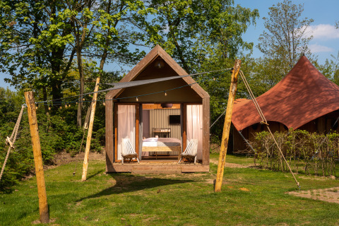 Kleine Boutique-Suite im Holiday Park Mölke, Niederlande, vor Bäumen, mit gemütlicher Terrasse.