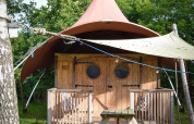 Foto de la tienda safari Dream Suite en Holiday Park Mölke, Países Bajos, con porche y banco de picnic exterior.