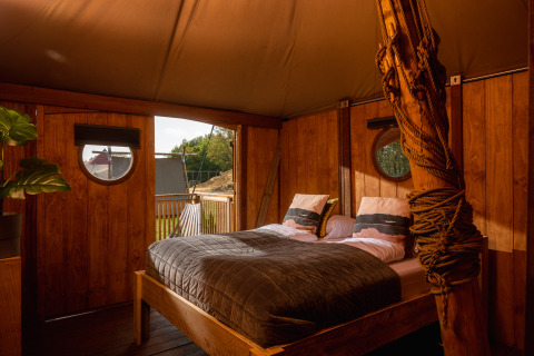 Interior de la tienda safari Dream suite en Holiday Park Mölke, Países Bajos, con cama doble acogedora.
