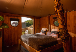 Indretning af soveværelse i Dream suite safari telt ved Holiday Park Mölke, Nederlandene, med dobbeltseng.