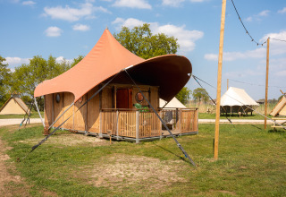 Safari-Zelt Dream Suite im Holiday Park Mölke in den Niederlanden mit Veranda und grüner Umgebung.