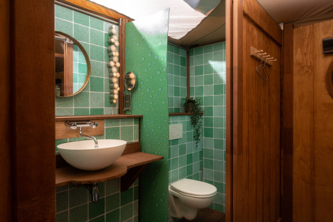 Badeværelse i Dream Suite safaritelten på Holiday Park Mölke, Holland, med grønne fliser og træfinish.